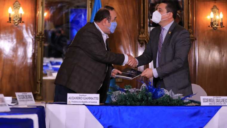El presidente Alejandro Giammattei (Izq.) recibe el informe de manos de Óscar Dávila, director ejecutivo de la Comisión contra la Corrupción. (Foto: Gobierno de Guatemala)