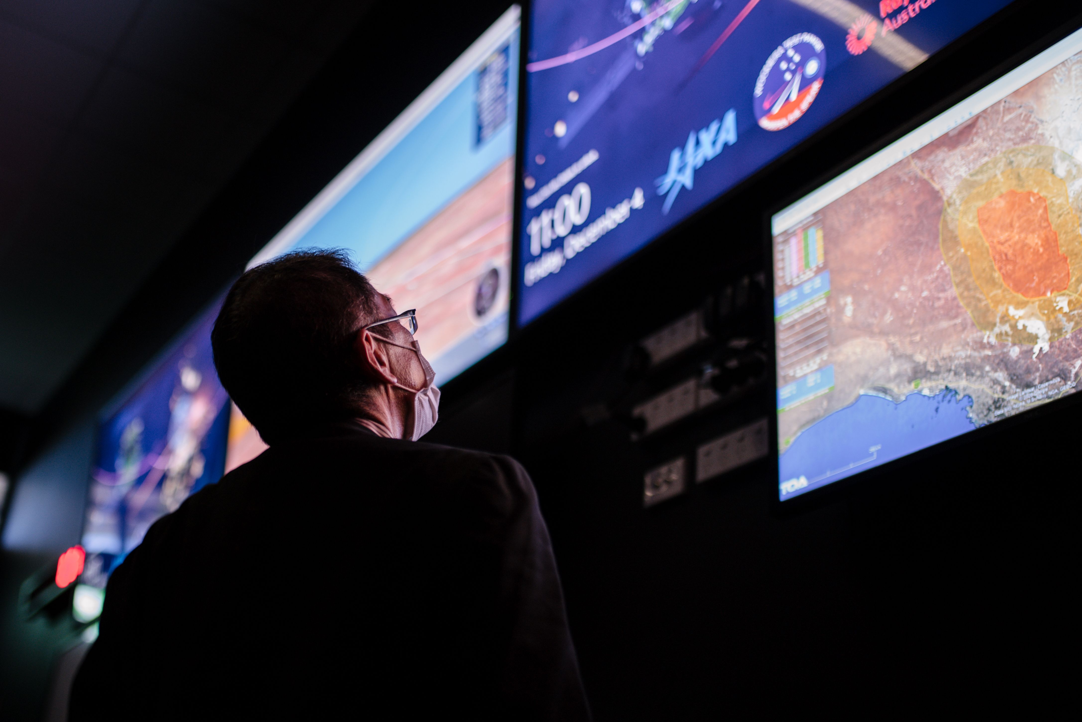 Toshio Yasuma, asesor del director de la agencia espacial japonesa JAXA, observa los monitores en el centro de operaciones de alcance del complejo de alcance Woomera de la Real Fuerza Aérea Australiana (RAAF) en Woomera en Australia del Sur el 4 de diciembre de 2020, antes de que la sonda Hayabusa 2 de la Agencia de Exploración Aeroespacial de Japón (JAXA) caiga a la tierra.  (Foto Prensa Libre: AFP).