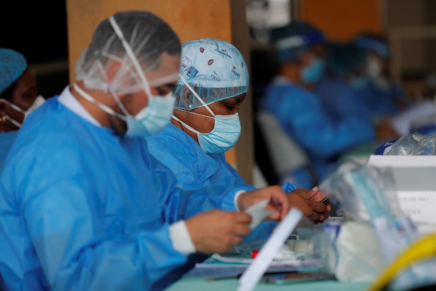 Personal médico del Ministerio de Salud de Panamá (MINSA), manipula una prueba de hisopado nasal para detectar la covid-19 en un puesto médico. (Foto Prensa Libre: EFE)