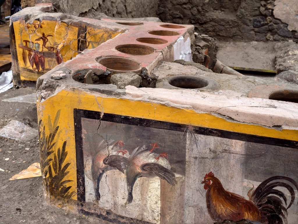 Detalle de la decoración descubierta en un termopolio, en el área arqueológica de Pompeya. (Foto Prensa Libre: EFE)