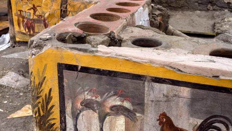 Detalle de la decoración descubierta en un termopolio, en el área arqueológica de Pompeya. (Foto Prensa Libre: EFE)