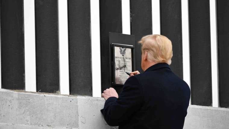 En uno de sus últimos actos como presidente Trump visitó el muro y estampó su firma en una placa colocada en la barrera.