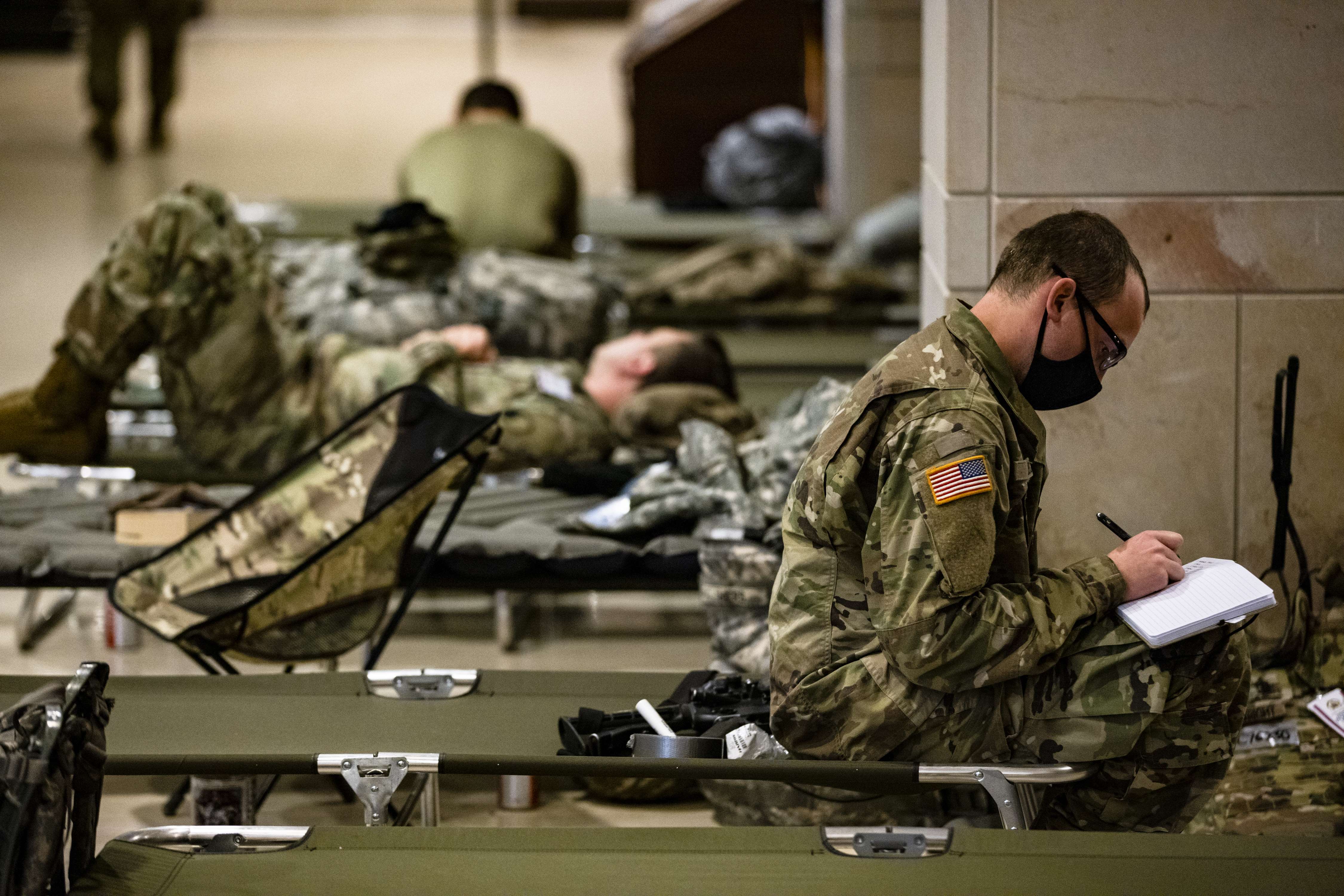 Soldados de la Guardia Nacional estadounidense toman un descanso en el centro de visitantes del Capitolio, en Washington. (Foto Prensa Libre: AFP)