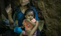 ACOMPAÑA CRÓNICA: GUATEMALA DESNUTRICIÓN - AME8935. LA PALMILLA (GUATEMALA), 12/01/2021.- Fotografía del 24 de octubre de 2020 que muestra a la pequeña niña Yesmin mientras es cargada por su madre en su vivienda en La Palmilla, Chiquimula (Guatemala). Yesmin murió este lunes de madrugada. Con sólo 2 años de edad, una neumonía originada por la desnutrición acabó con su vida en el este de Guatemala. Durante las últimas semanas luchó por subir de peso, pero las secuelas de su nacimiento prematuro, su mala alimentación y las condiciones de su hogar la debilitaron. El caso de desnutrición de Yesmin, uno más de los cientos que cada año se registran en Guatemala, fue conocido en octubre pasado por Efe de la mano de la organización Antigua al Rescate, una entidad no gubernamental que asiste a familias en riesgo alimentario y que intentó hasta los últimos esfuerzos apoyar a la niña de dos años. EFE/ Esteban Biba ARCHIVO