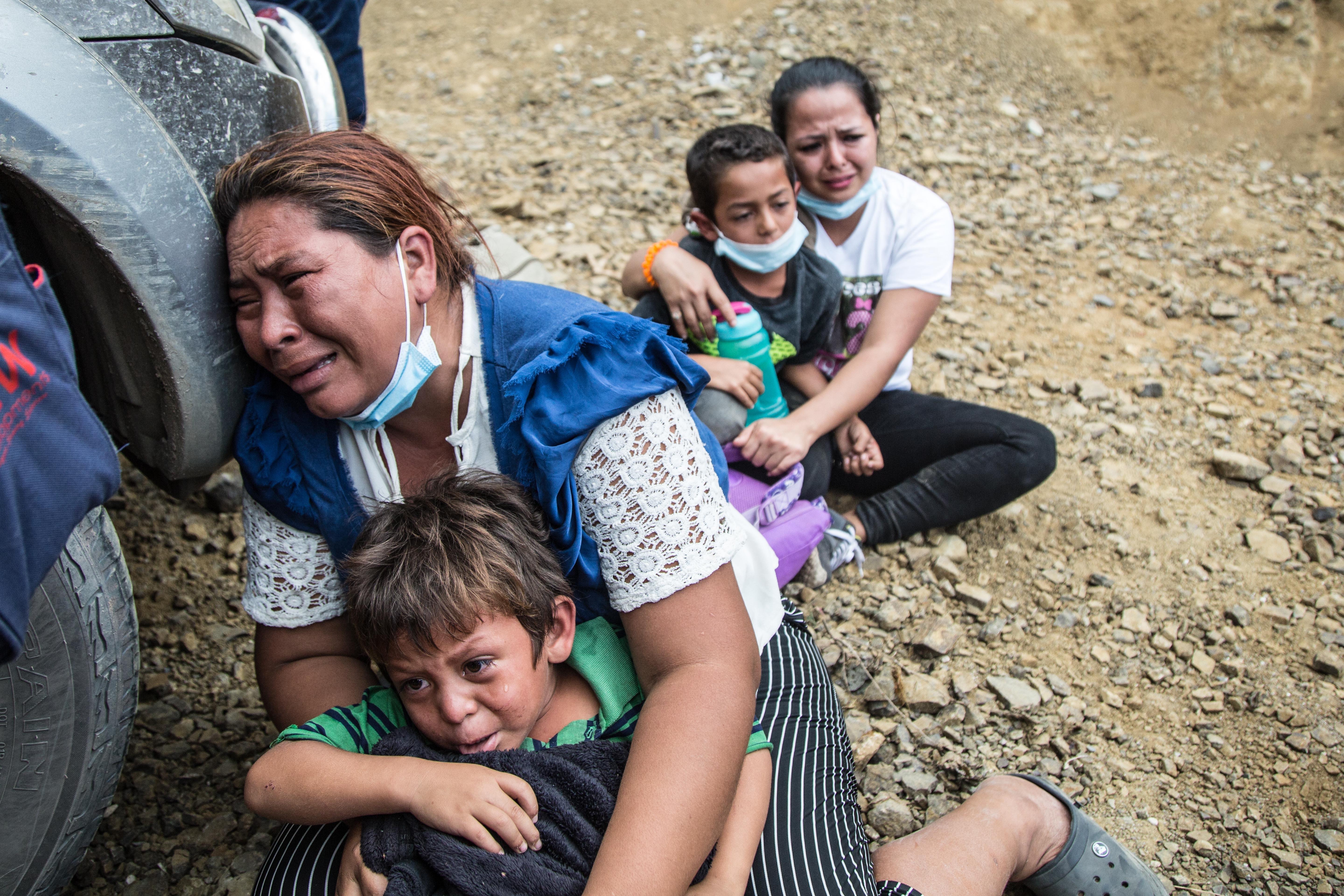 Una migrante llora junto a su hijo luego que la Policía disolviera la caravana de miles de personas que bloqueba  una carretera en Vado Hondo, Chiquimula. (Foto Prensa Libre: EFE)