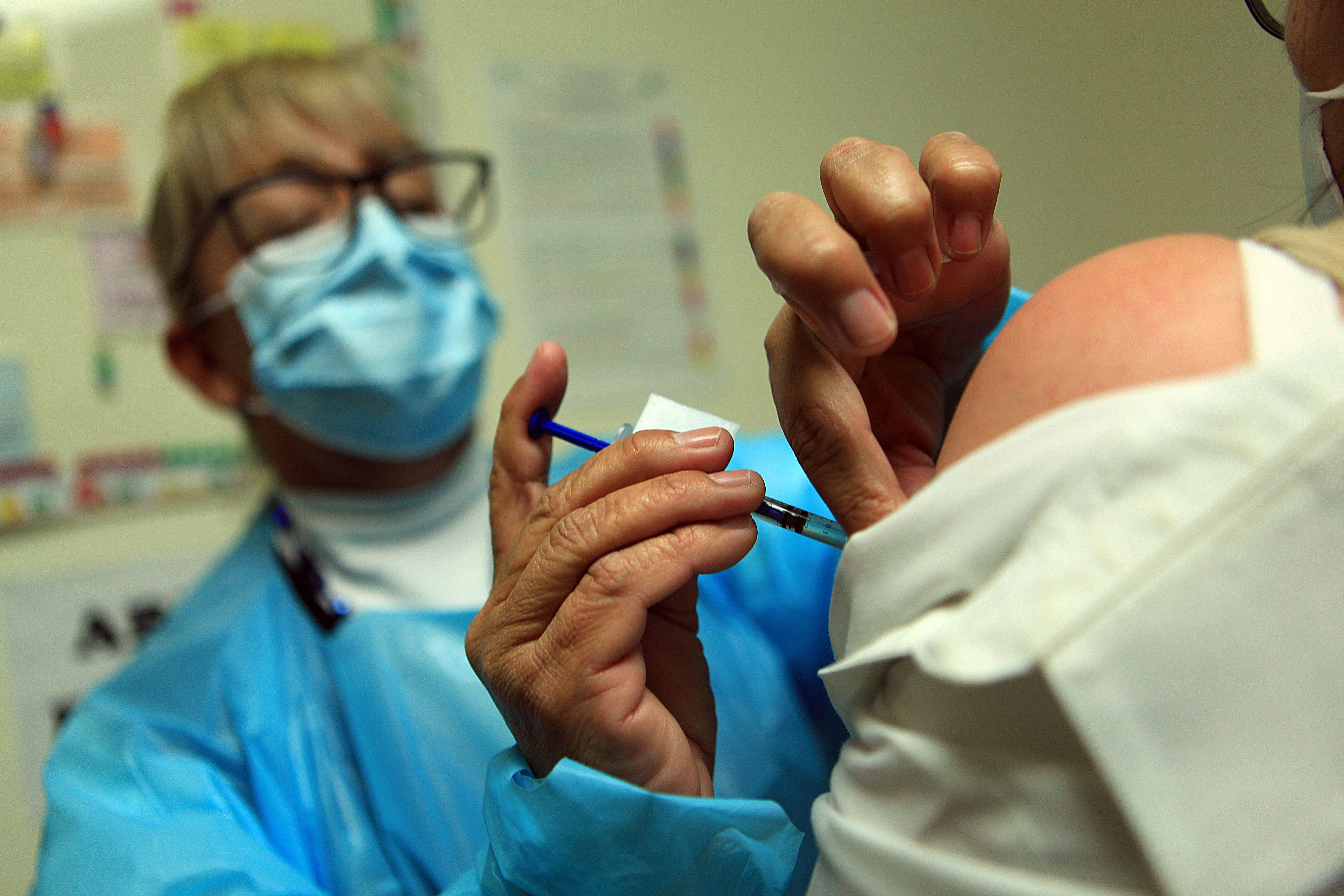 Una empleada de la salud aplica la vacuna contra el covid-19 a una de sus compañeras en el Hospital General de la fronteriza Ciudad Juárez, México). (Foto Prensa Libre: EFE)