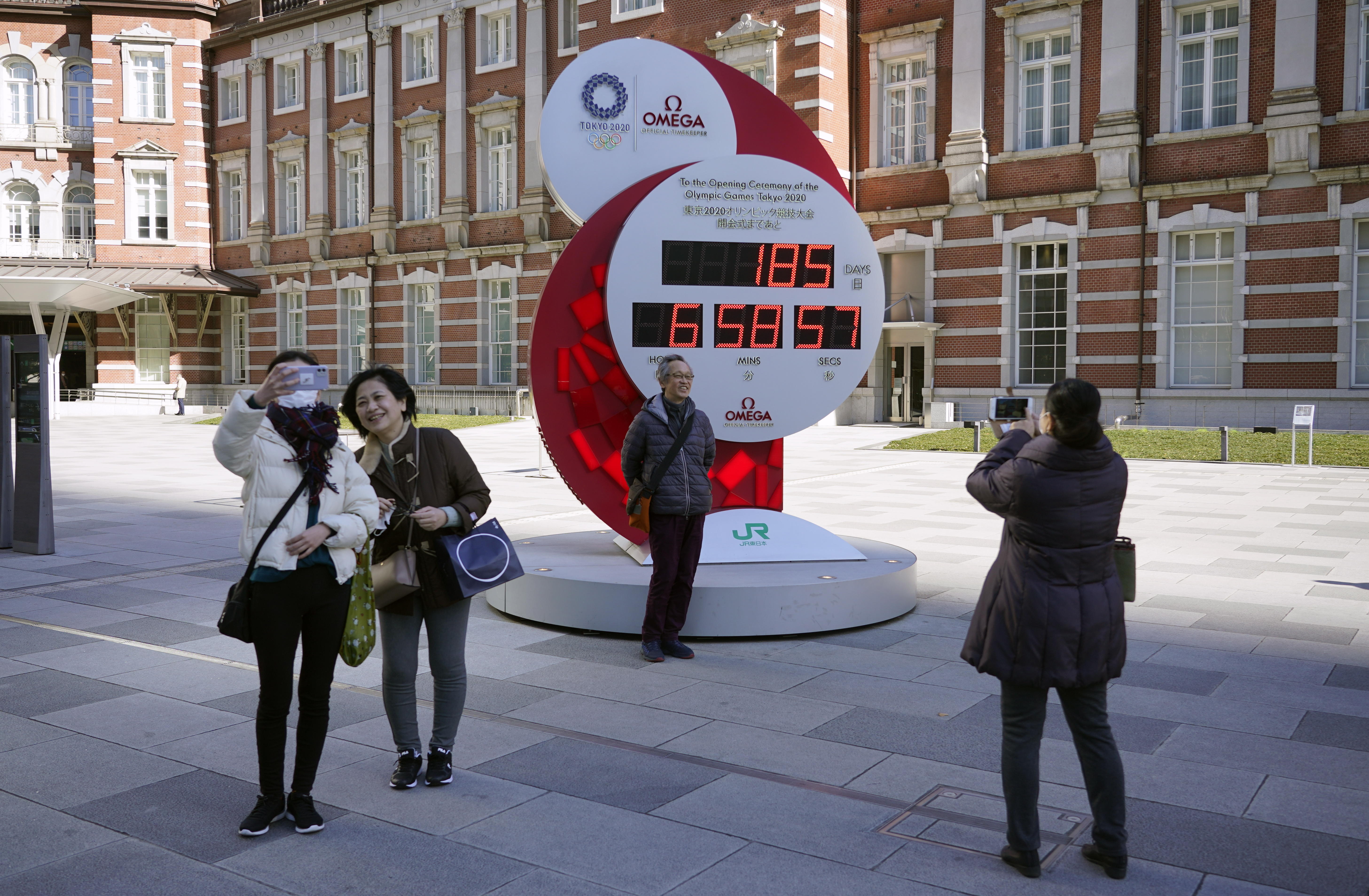 Las personas se toman fotos en un reloj que marca el conteo hacia los Juegos Olímpicos de Tokio 2022. Foto Prensa Libre: EFE.