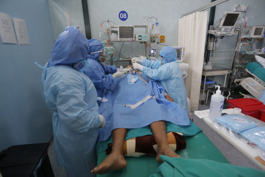 Salubristas atienden a un paciente con coronavirus en Callao. (Foto Prensa Libre: EFE)