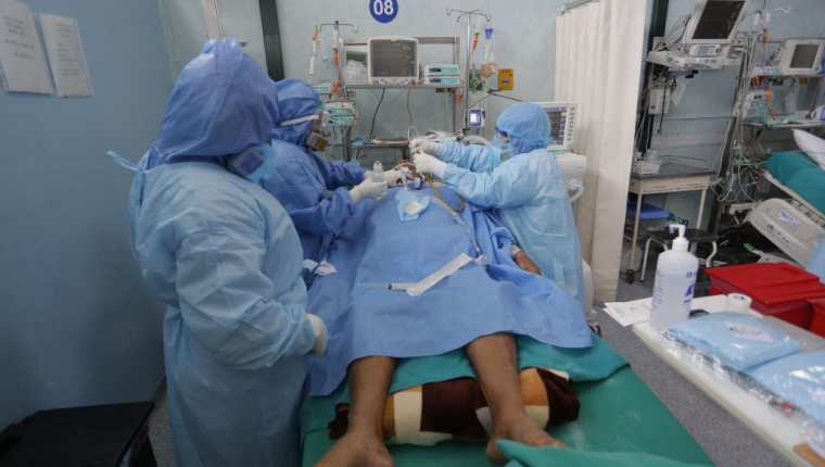 Salubristas atienden a un paciente con coronavirus en Callao. (Foto Prensa Libre: EFE)