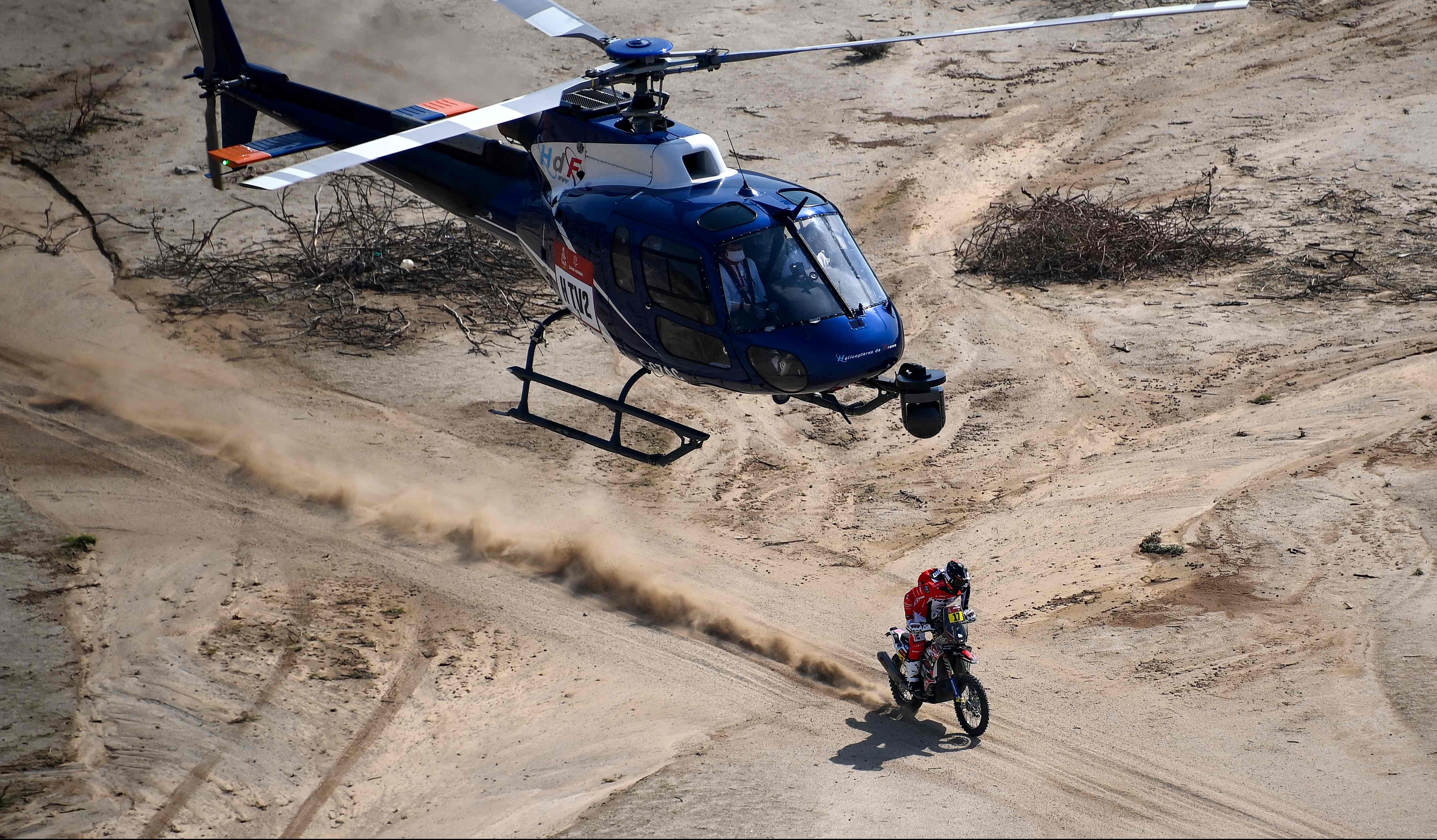 Un helicóptero vigila el paso del corredor español Juan Pedroro Garcia durante la etapa de prólogo del Rally Dakar. (Foto Prensa Libre: AFP)