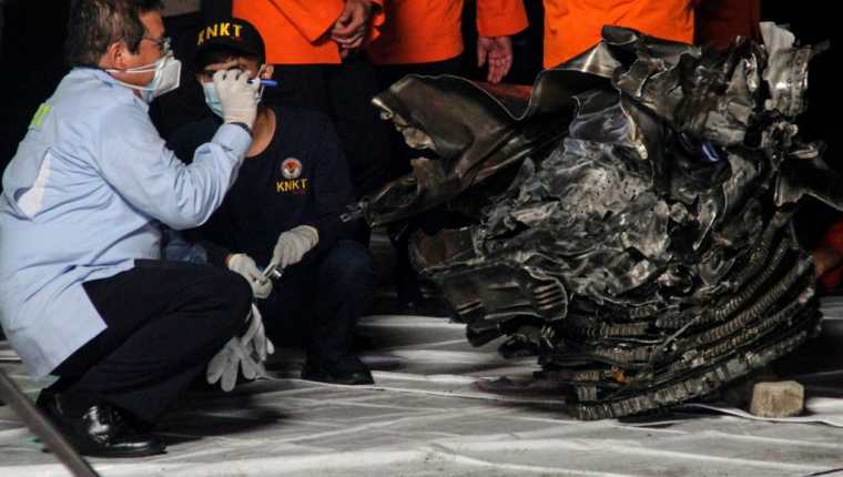 Autoridades inspeccionan las partes localizadas del avión de Sriwijaya Air, el cual se estrelló en Yakarta. (Foto Prensa Libre: AFP)