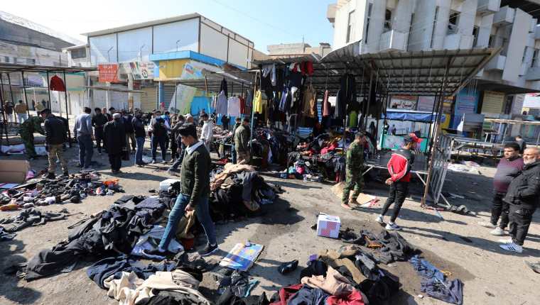 Iraquíes limpian el lugar de una explosión de una bomba en un mercado de ropa usada en el centro de Bagdad. (Foto Prensa Libre: EFE)