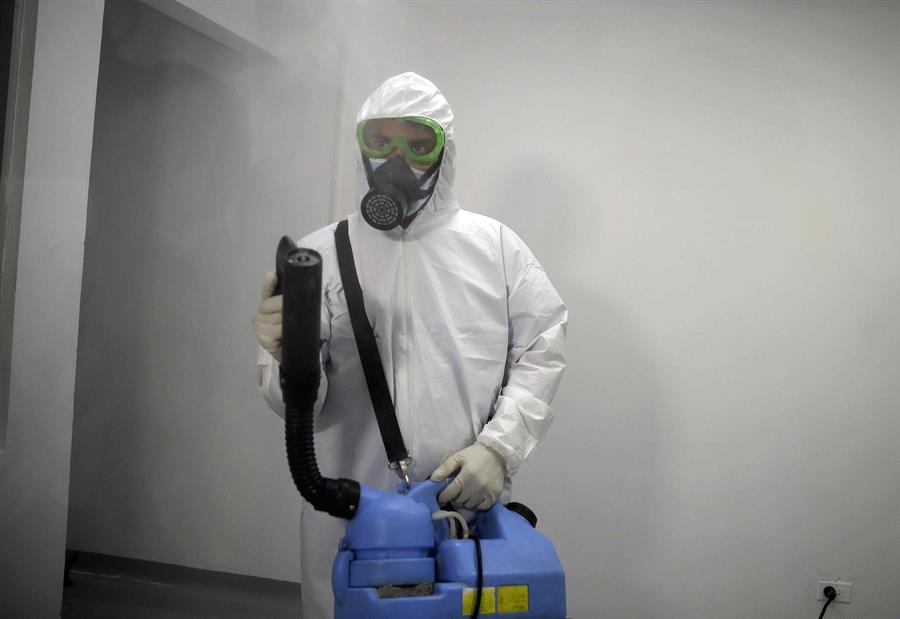 Un auxiliar del personal de aseo desinfecta un sector destinado para atender pacientes de covid-19 en San Salvador, El Salvador. (Foto Prensa Libre: EFE)