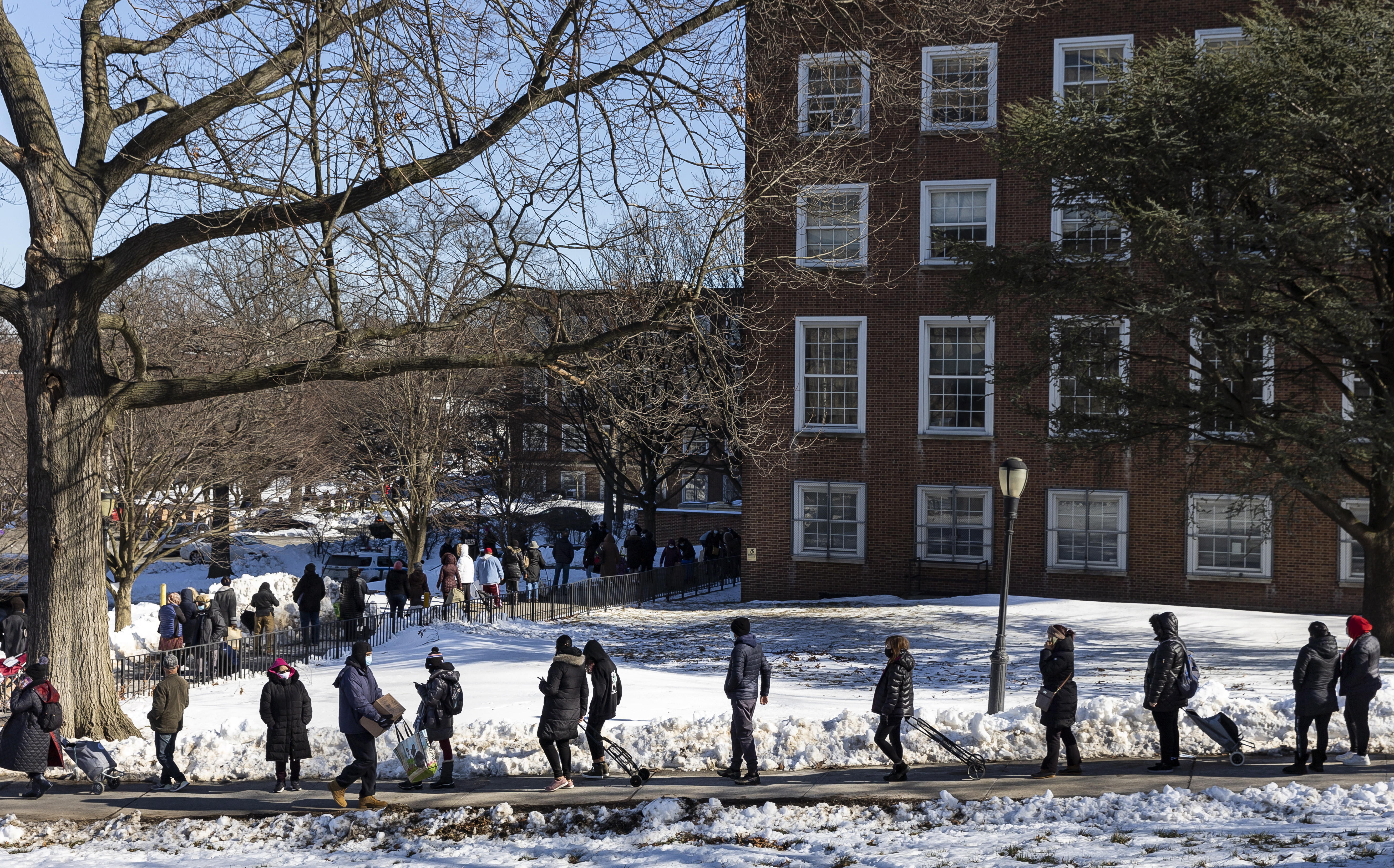 Personas hacen fila para recoger una caja de alimentos en un refugio ubicado en la ciudad de Queens, en Nueva York. (Foto Prensa Libre: EFE)