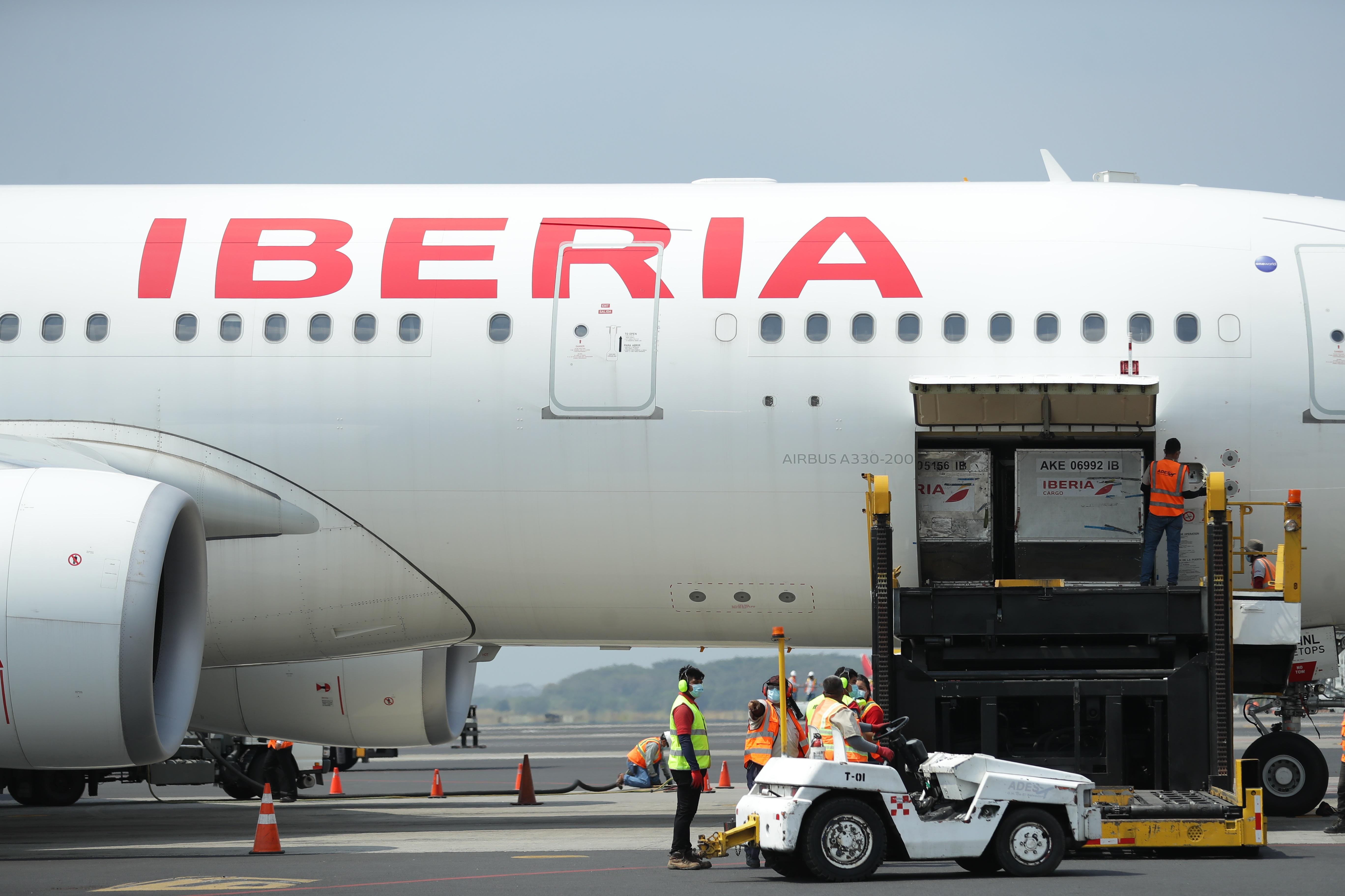 Trabajadores aeroportuarios descargan de un avión un primer lote de vacunas contra la covid-19  en el aeropuerto internacional "Monseñor Óscar Romero" de San Luis Talpa, El Salvador. (Foto Prensa Libre: EFE)