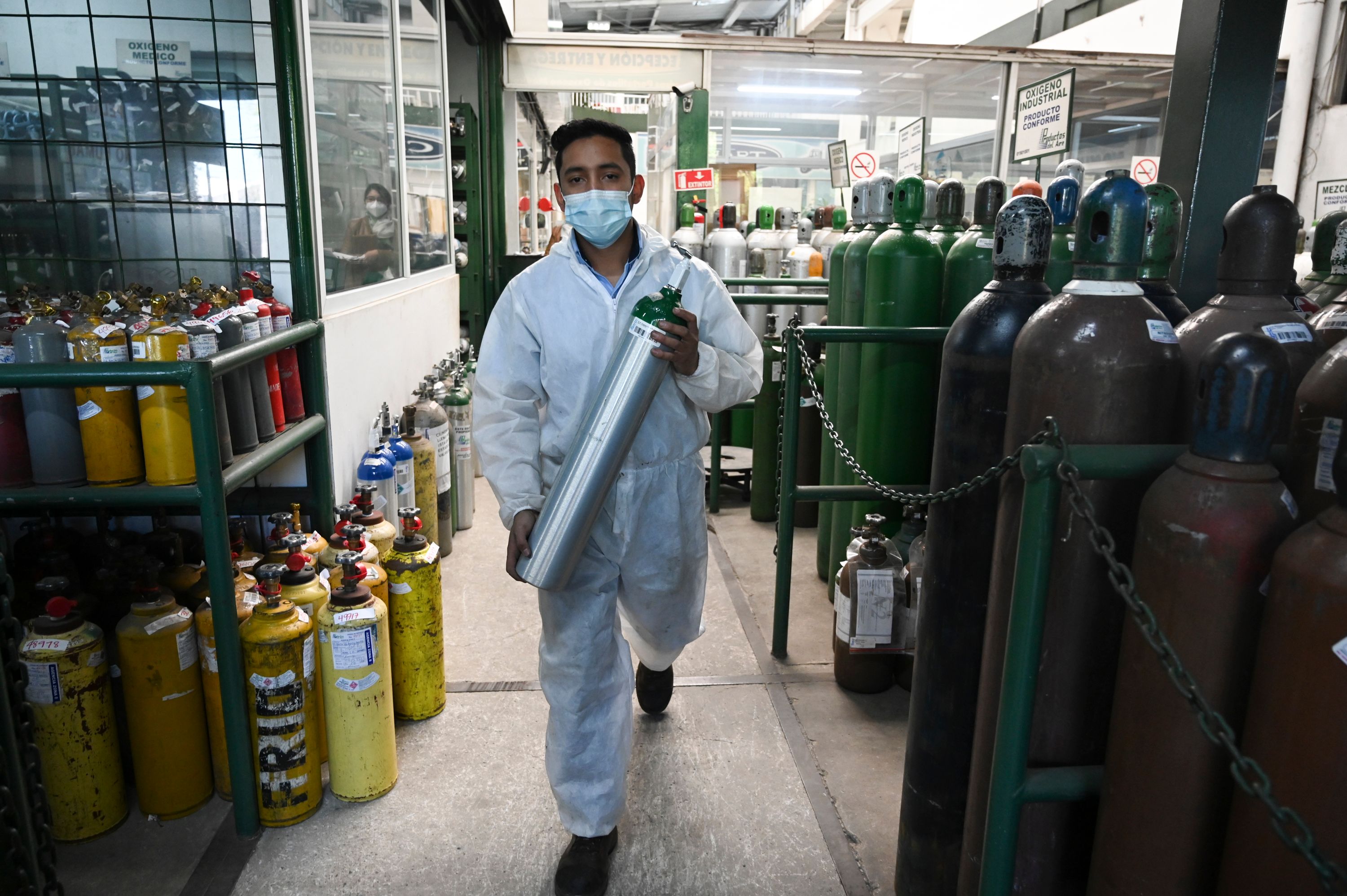 Un trabajador de Salud prepara tanques de oxígeno para ser distribuidos en hospitales  para personas infectadas con coronavirus. (Foto Prensa Libre: AFP)