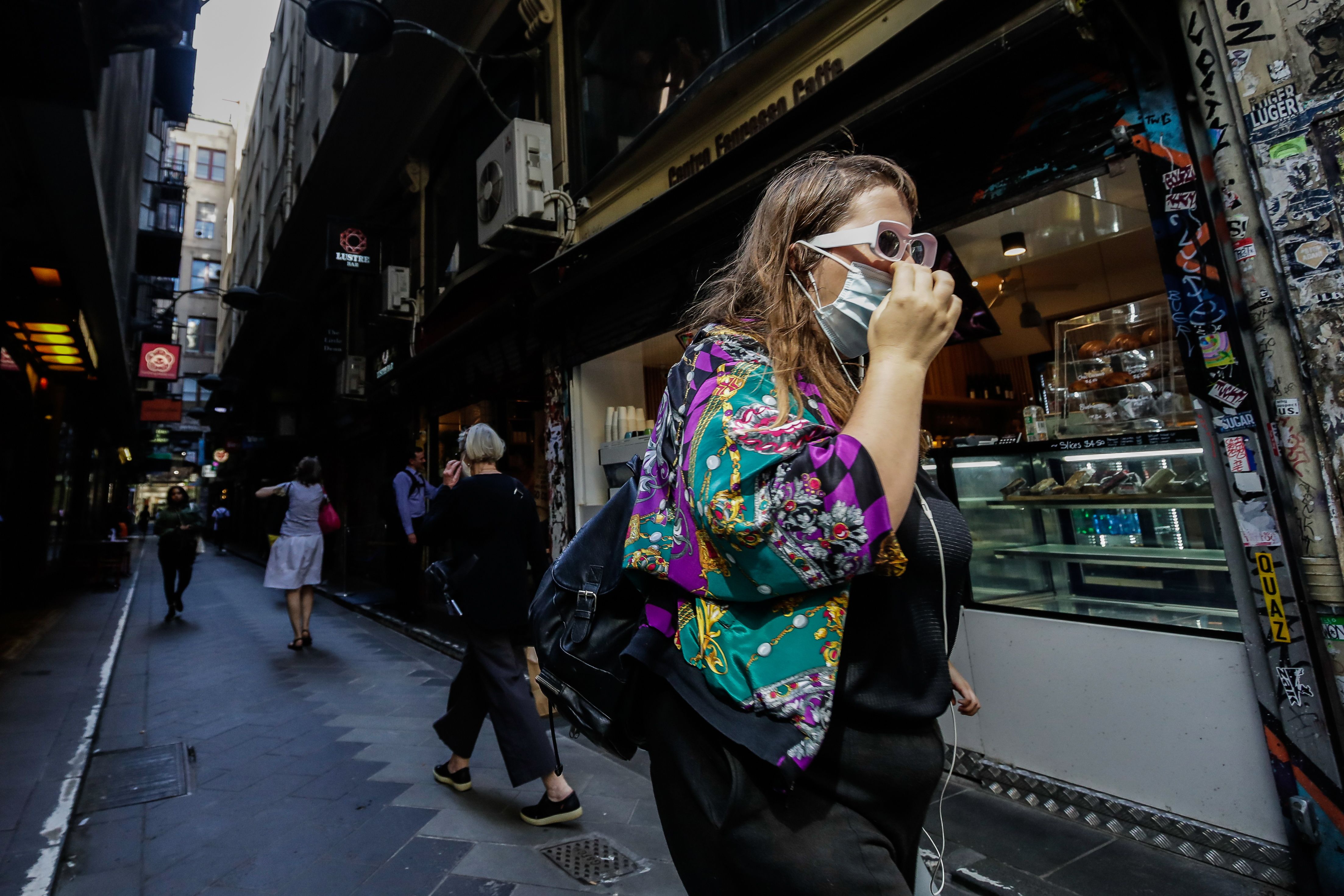 Mujer camina por calles de Melbourne, Australia, usando mascarilla. (Foto: AFP)