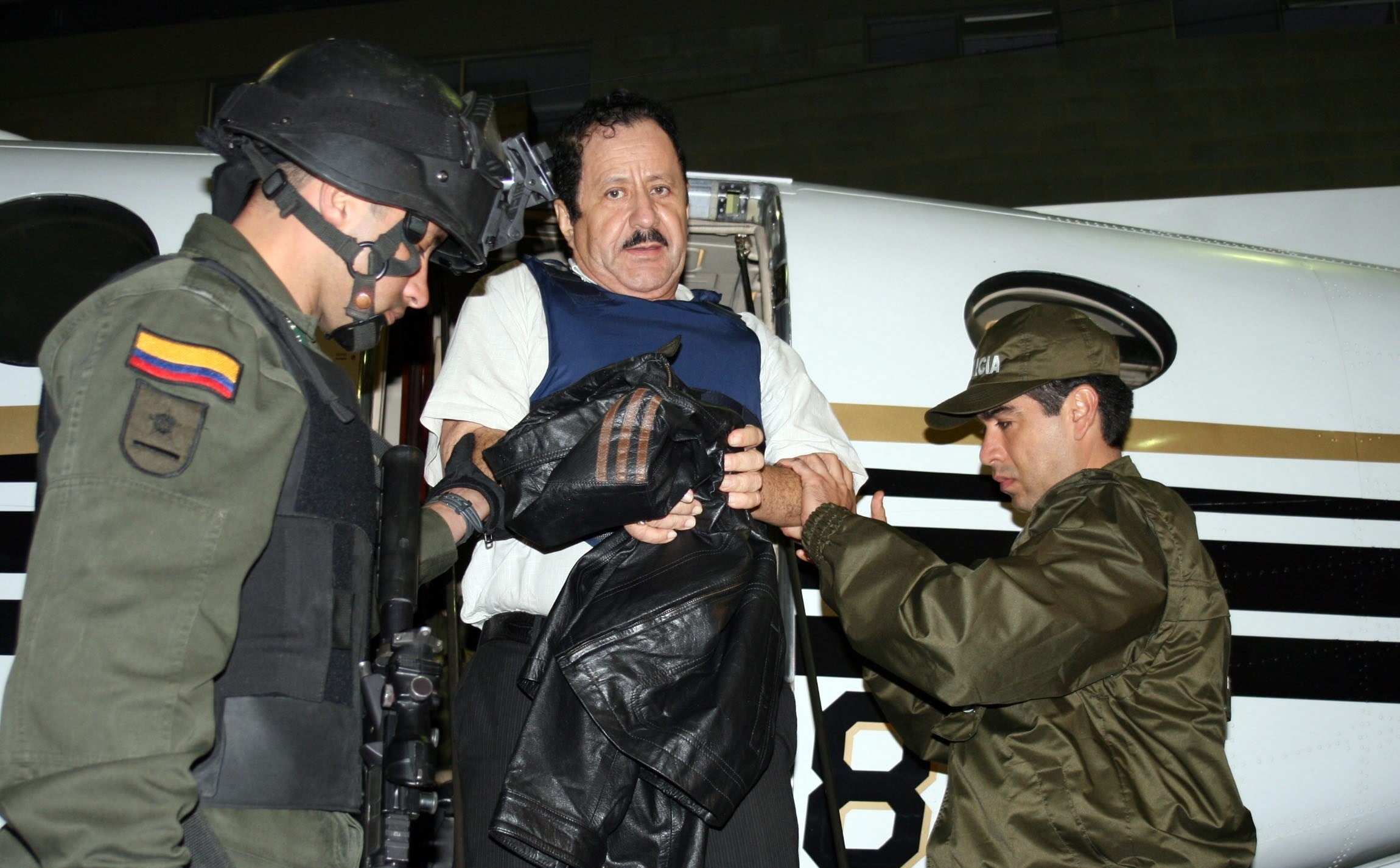 Fotografía de archivo cedida por la Policía Nacional de Colombia que muestra a varios agentes mientras custodian al exjefe paramilitar Hernán Giraldo antes de su extradición a Estados Unidos, el 13 de mayo de 2008, en Bogotá, Colombia. (Foto Prensa Libre: EFE)