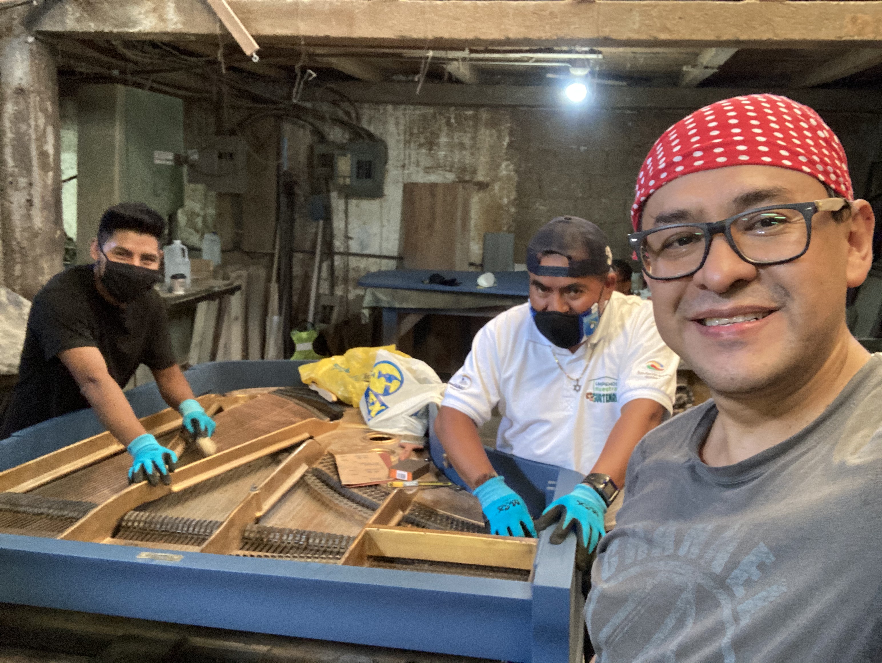 Elías, Demetrio e Iván, del  equipo de Casa de Pianos, restauran por dentro un piano Blüthner. (Foto Prensa Libre: cortesía Casa de Pianos).