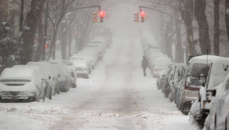 Un hombre busca cruzar la calle a través de la nieve en el distrito de Brooklyn de la ciudad de Nueva York. (Foto Prensa Libre: AFP)