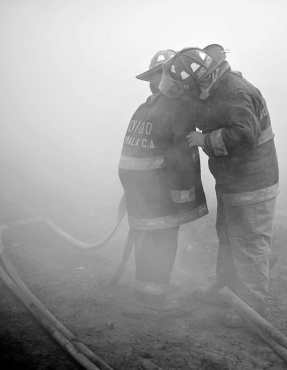 La galonista Sharon Ramos auxilia a uno de sus compañeros, en el momento en que una nube de humo no le permitía respirar. (Foto Prensa Libre: Carlos Hernández Ovalle)