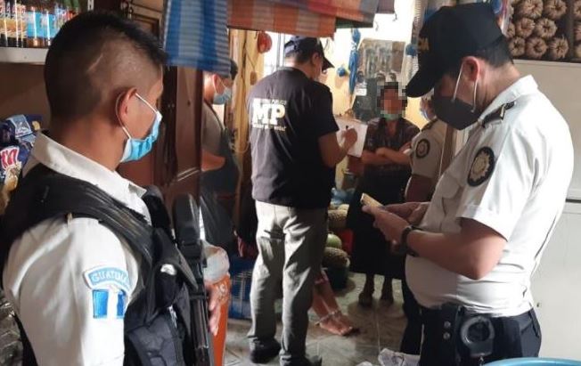 Agentes fiscales y de la Policía durante la captura de la mujer que tenía encadenada a su hija en Joyabaj, Quiché. (Foto Prensa Libre: PNC)