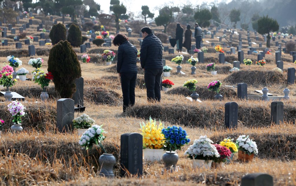 Familias en Corea del Sur despiden a sus seres queridos víctimas de la pandemia. (Foto Prensa Libre: EFE)