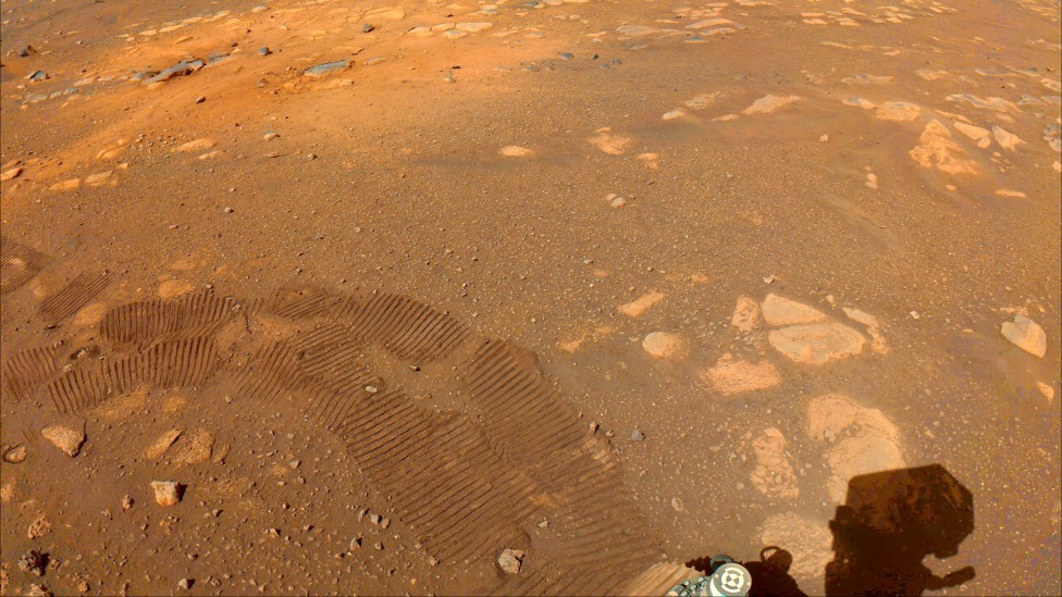 Las huellas del robot Perseverance pueden verse en esta imagen captada por una de sus cámaras el 5 de marzo. Uno de los objetivos de la misión es buscar señales de vida microbiana antigua. (NASA/JPL-CALTECH)