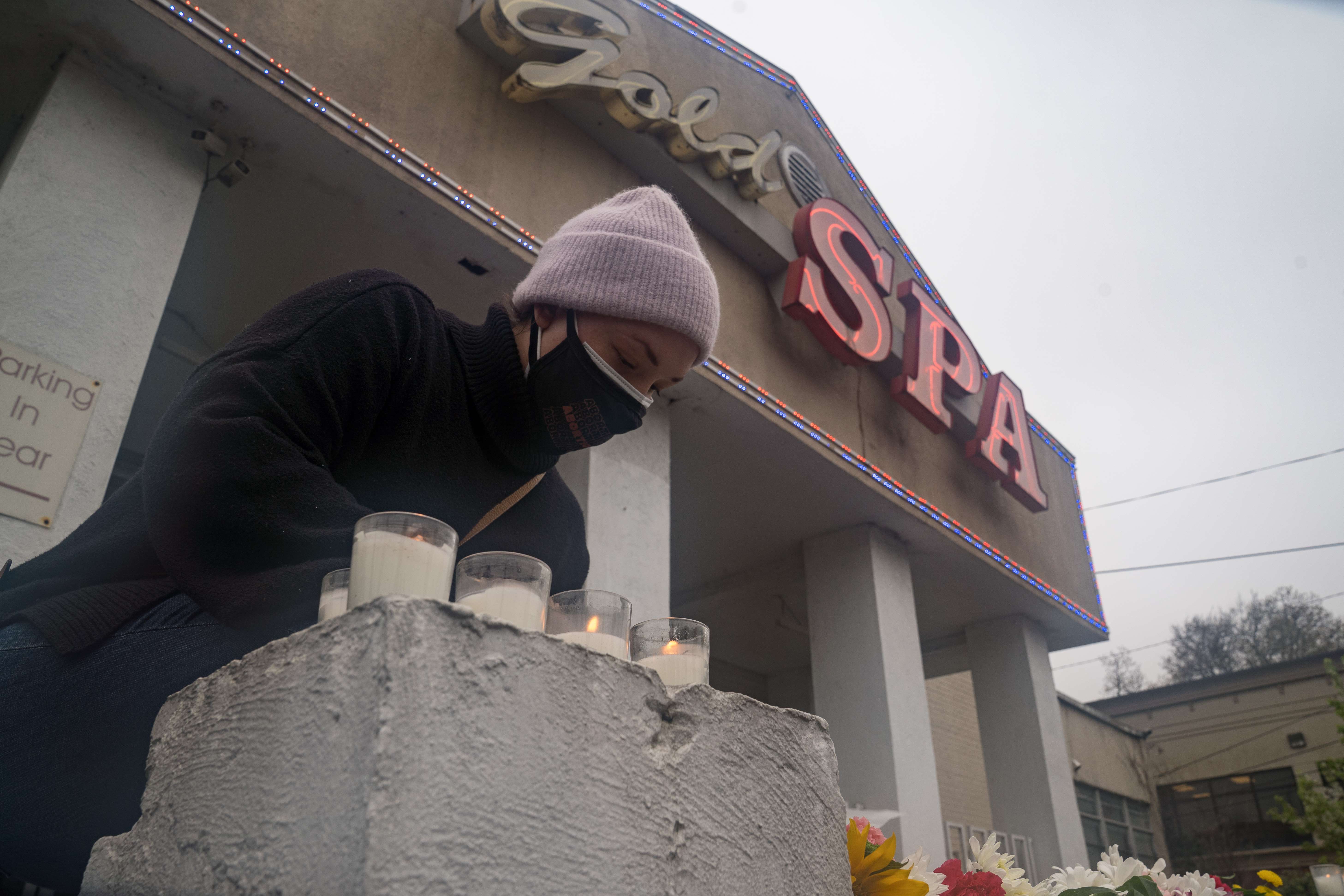 Personas llevan ofrendas florales frente a los salones en donde ocurrió la matanza en Atlanta. (Foto Prensa Libre: AFP)