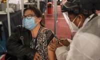 AME2060. CIUDAD DE GUATEMALA (GUATEMALA), 13/03/2021.- Una mujer recibe una vacuna contra la covid-19 el 10 de marzo de 2021, en el campo polideportivo del barrio Gerona, en Ciudad de Guatemala (Guatemala). Guatemala cumplió este sábado un año desde que detectó el primer caso de la covid-19 en su territorio, con más de 181.000 contagios y 6.500 muertes y continúa con su proceso de vacunación rezagada, con el 0,13 % de personas inmunizadas en los últimos 15 días. EFE/ Esteban Biba