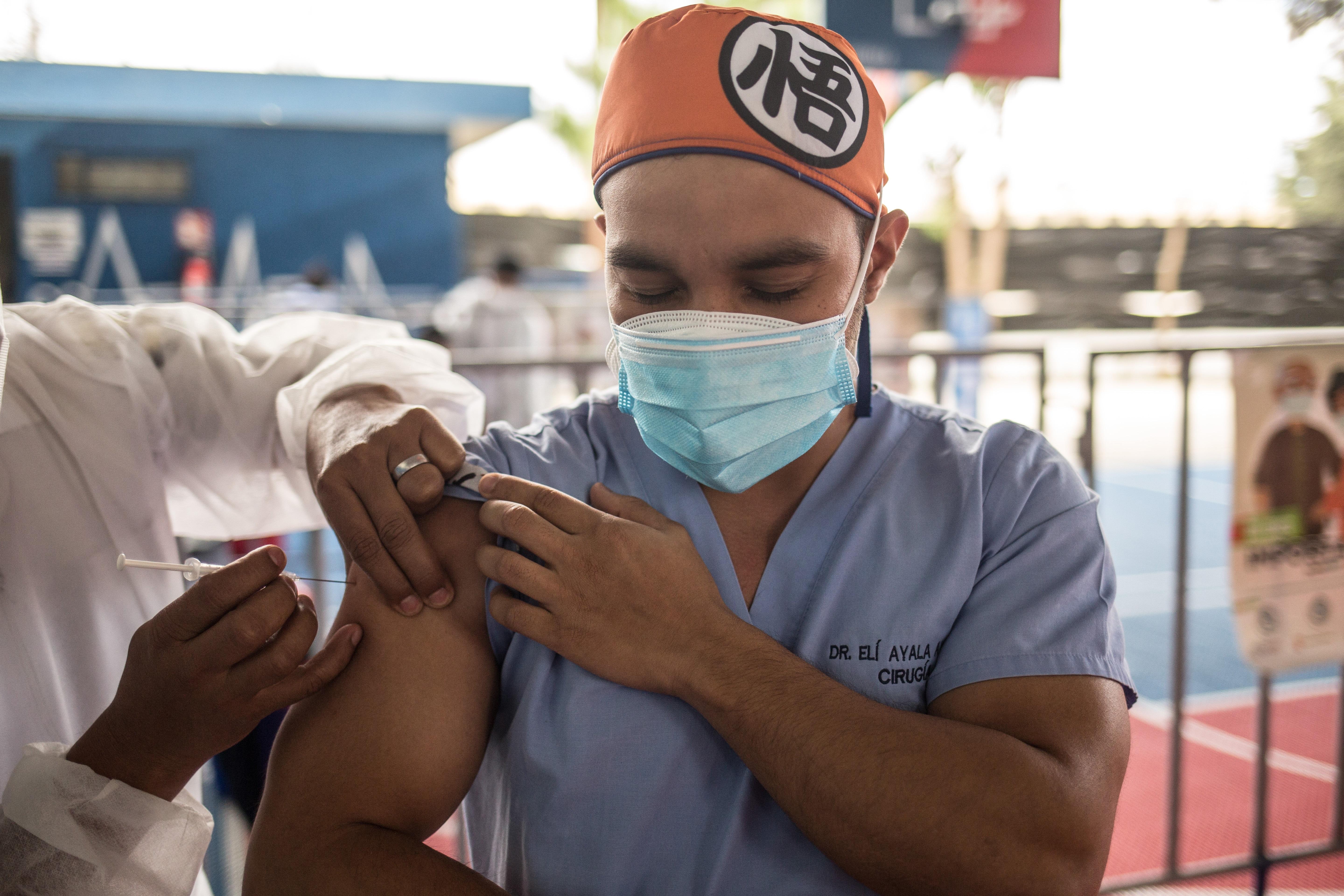 Un médico recibe una vacuna contra la covid-19 el 10 de marzo de 2021, en el campo polideportivo del barrio Gerona. (Foto Prensa Libre: EFE)