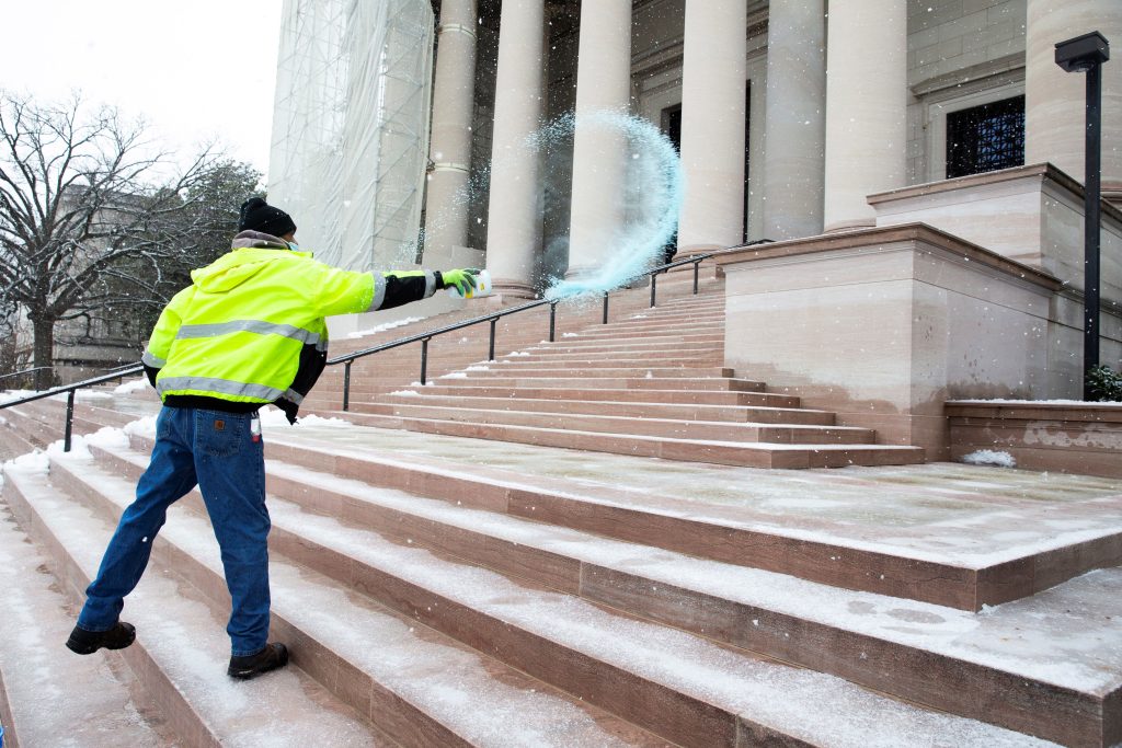 AME3113. WASHINGTON (ESTADOS UNIDOS), 17/03/2021.- Fotografía de archivo del 19 de febrero de 2021 que muestra a un hombre que lanza sal a las escalinatas principales de la Galería Nacional de Arte durante una nevada, en Washington (EE.UU.). Hace ocho décadas, en plena Segunda Guerra Mundial, el presidente estadounidense, Franklin D. Roosevelt, pronunciaba el discurso de inauguración de la Galería Nacional de Arte, a la que calificaba de "regalo a la nación" que permitiría ver en Washington de manera permanente obras maestras de la historia de la pintura universal. Solo ha habido dos épocas en las que sus operaciones diarias se han visto alteradas: en 1942 estuvo parcialmente cerrada, y se trasladaron a Carolina del Norte parte de sus obras más apreciadas para su protección durante la guerra; y en 2020, y en lo que llevamos 2021, debido a la pandemia del coronavirus. EFE/ Michael Reynolds ARCHIVO