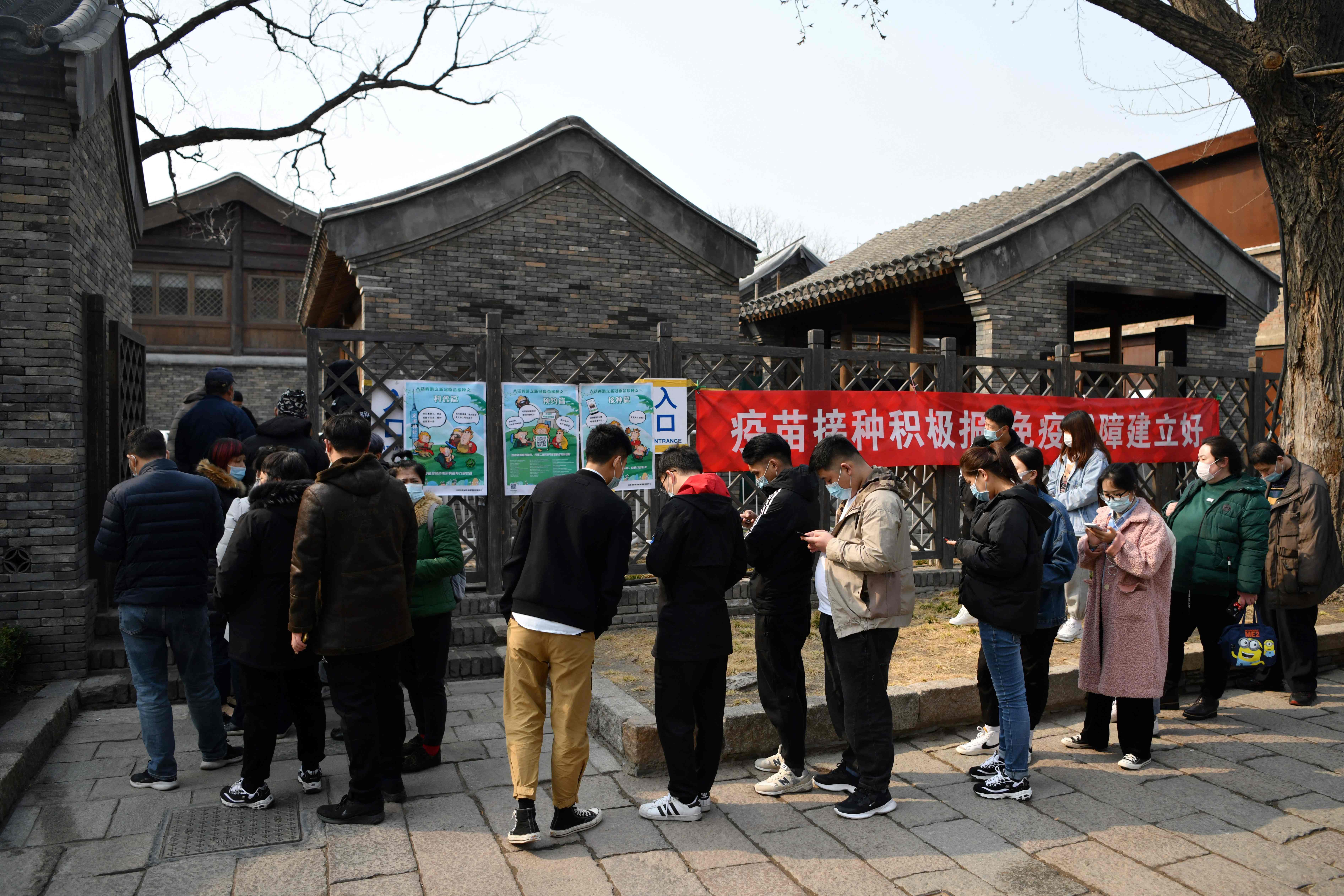 Personas esperan para recibir la vacuna contra el covid-19 en Pekín, China. (Foto Prensa Libre: AFP)