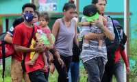 Migrants heading for the US are seen in Corinto, Honduras, on March 30, 2021 before trying to cross the border into Guatemala. - Guatemala on Monday authorized the use of force at its border with Honduras to block a new US-bound migrant caravan it said posed a coronavirus contagion risk. Hundreds of migrants gathered in northern Honduras started pushing into Guatemala on Tuesday, hoping to travel onwards to Mexico and the United States, according to Guatemalan migration authorities. (Photo by Wendell ESCOTO / AFP)