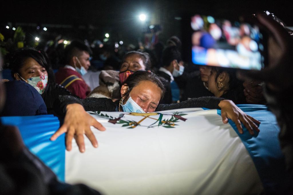 Sobre los ataúdes se colocaron banderas de Guatemala, además que familias portaron fotografías de las víctimas del asesinato.  (Foto Prensa Libre: EFE)