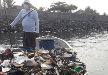Trabajador transporta basura recolectada en la playa de Puerto San José. (Foto Prensa Libre: Tomada de página de la comuna)