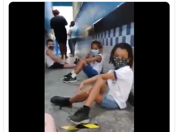 Los niños se lanzan al suelo y guardan distanciamiento social para protegerse de una balacera, en Río de Janeiro, Brasil. (Foto Prensa Libre: Captura de pantalla)
