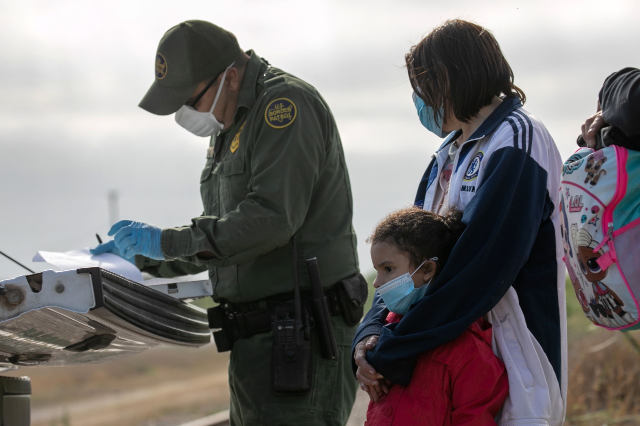 Un agente de la Patrulla Fronteriza revisa los papeles de una mujer y una niña al llegar a la frontera sur. (Foto Prensa Libre: Hemeroteca PL)
