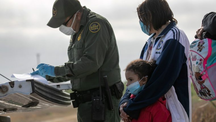 Un agente de la Patrulla Fronteriza revisa los papeles de una mujer y una niña al llegar a la frontera sur. (Foto Prensa Libre: Hemeroteca PL)