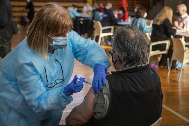 Los vacunados se preguntan si pueden relajar el distanciamiento social y el uso de la mascarilla. AP Photo/Darko Bandic