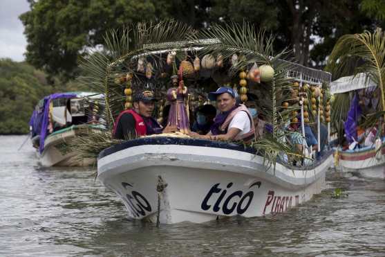 Feligreses cargan imágenes religiosas en embarcaciones durante un viacrucis acuático, en Granada, Nicaragua. (Foto Prensa Libre: EFE)