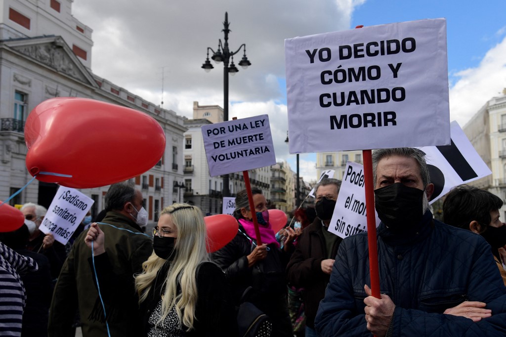 Un hombre sostiene un cartel que dice "Yo decido cuándo y cómo morir" durante una manifestación en apoyo de una ley que legaliza la eutanasia en Madrid, España. (Foto Prensa Libre: AFP)