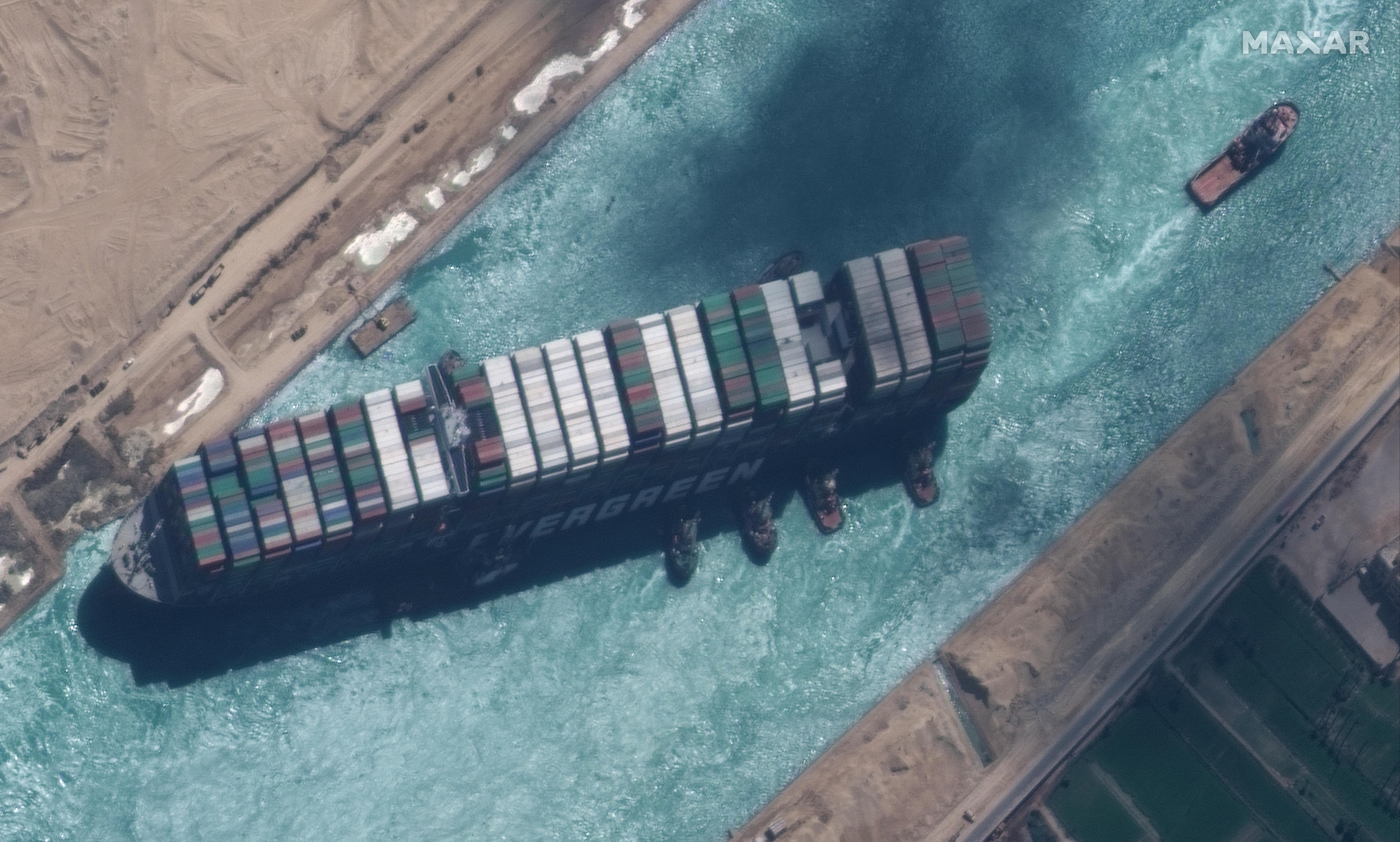 Una imagen satelital facilitada por MAXAR Technologies muestra, el buque portacontenedores Ever Given después de haber sido alejado de la orilla oriental del canal y remolcadores que intentan reposicionar el barco, en el Canal de Suez. (Foto Prensa Libre: EFE)
