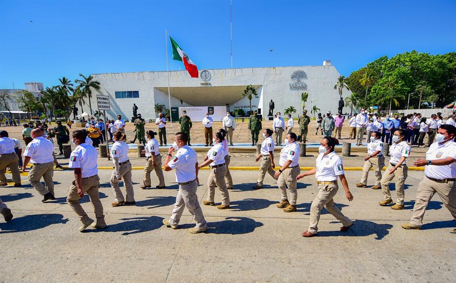 Integrantes del Instituto Nacional de Migración (INM) pasan frente a autoridades federales  en Villahermosa, estado de Tabasco, México. (Foto Prensa Libre: EFE)