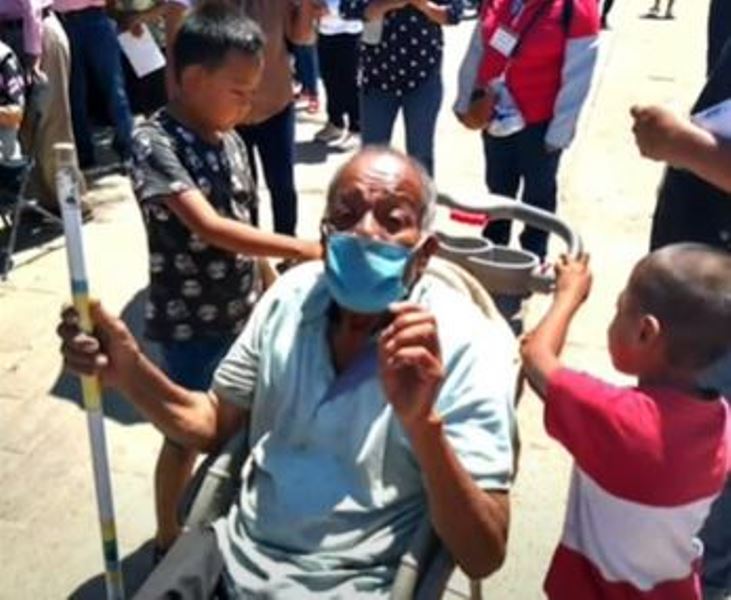 Victorio García llega al centro de vacunación en un carrito de bebé empujado por sus bisnietos. 