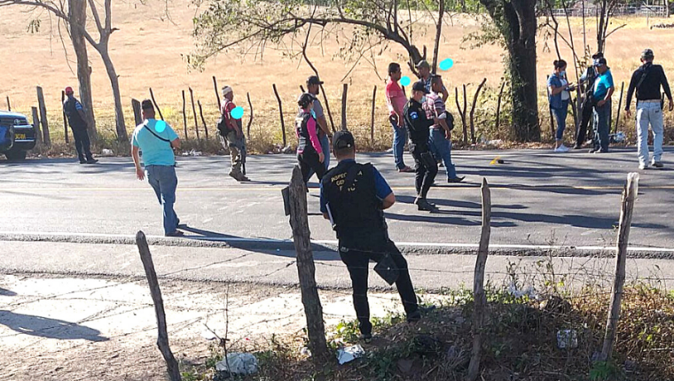 Policías, fiscales y hombres vestidos de civil con armamento pesado rodean la escena donde se observa, además, casquillos en el asfalto.