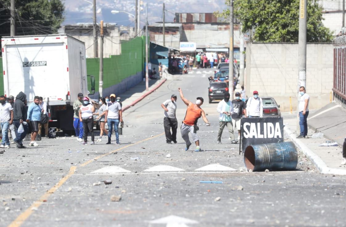 Supuestos invasores lanzan piedras contra vecinos de Nimajuyú. (Foto Prensa Libre: Erick Ávila)
