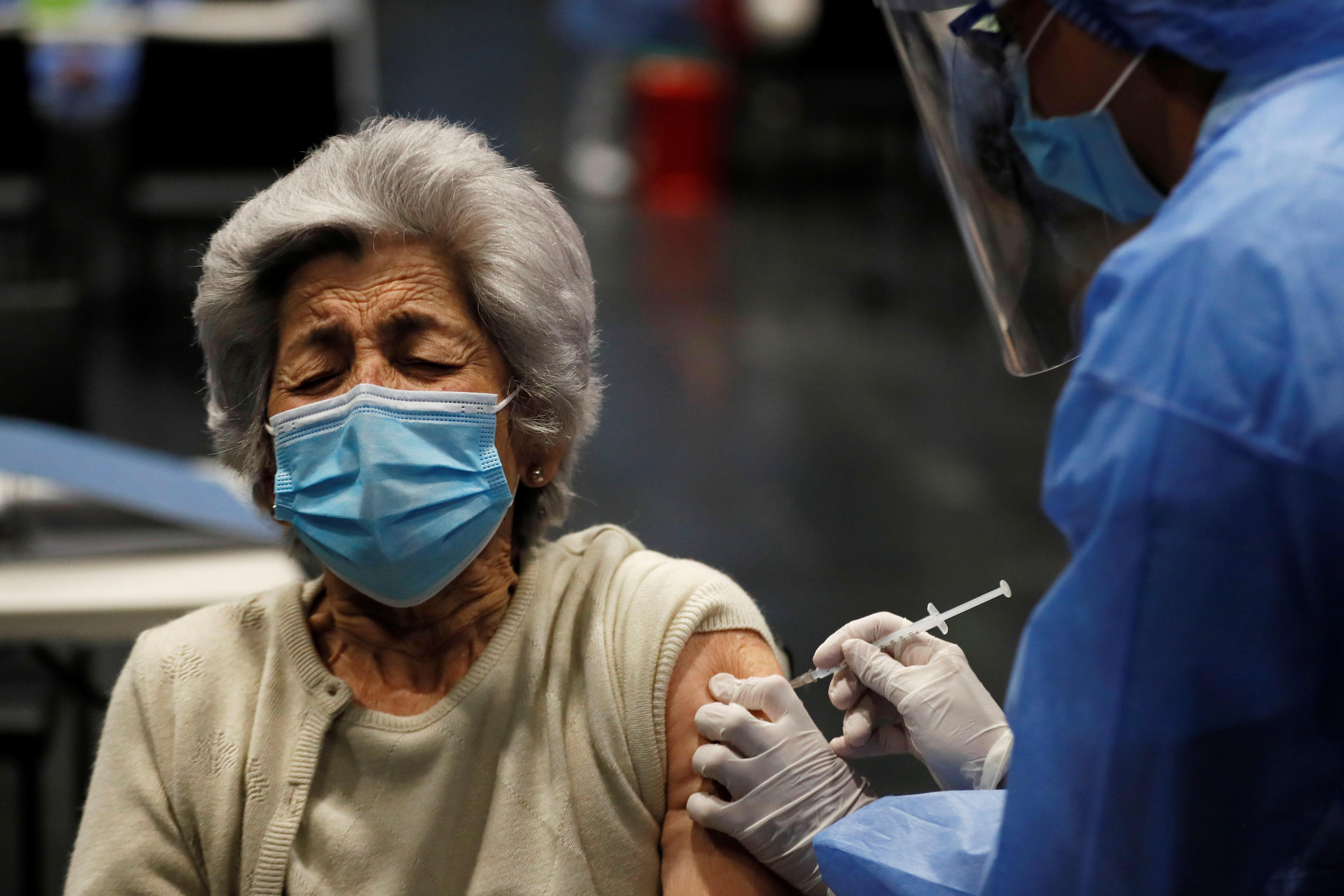 La vacunación en la segunda fase incluye a adultos mayores de 70 años. En la foto una anciana recibe la vacuna en Colombia. (Foto Prensa Libre: EFE)