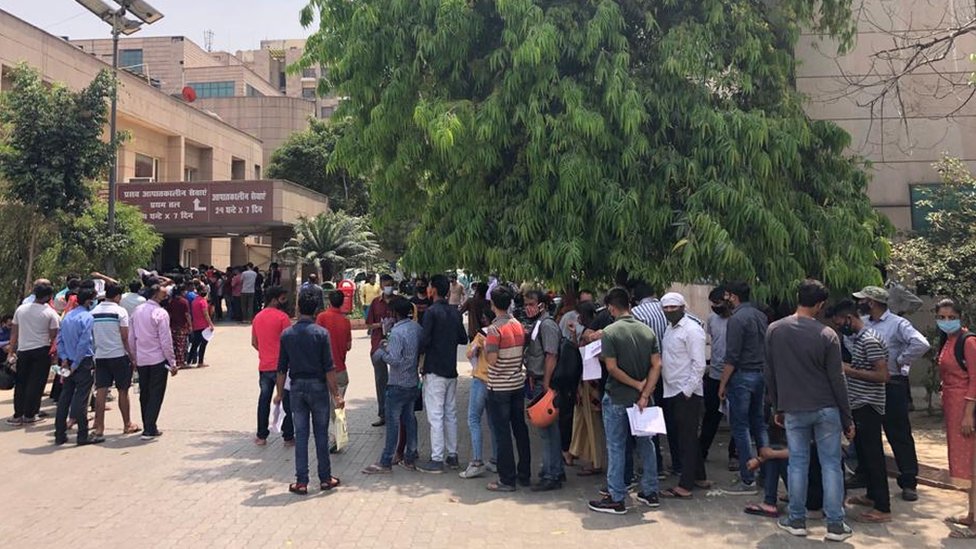 Gente esperando una prueba de covid frente a un hospital administrado por el gobierno en Noida.