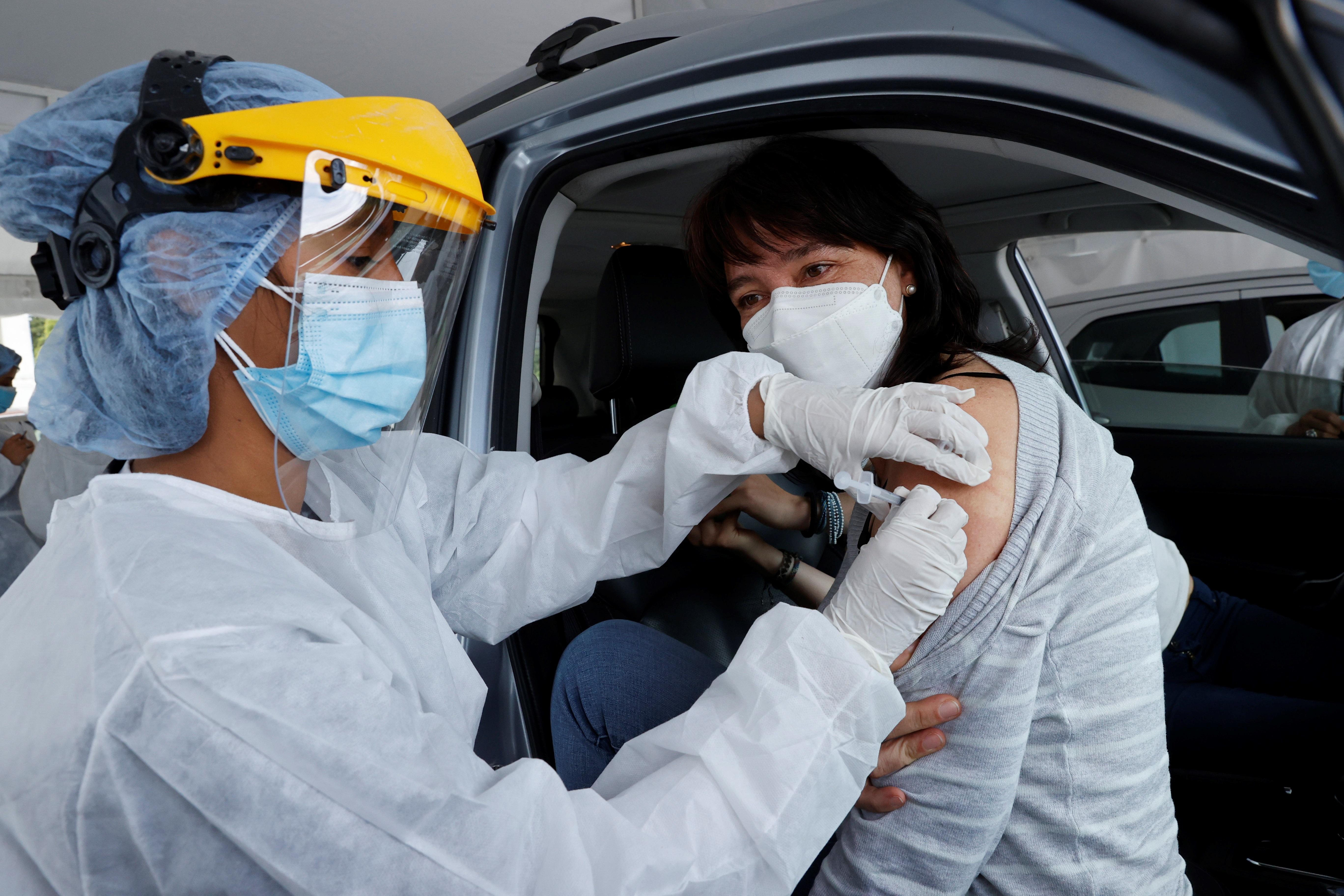Una mujer recibe una dosis de vacuna contra el covid-19, dentro de su vehículo, en Bogotá, Colombia. (Foto Prensa Libre: EFE)